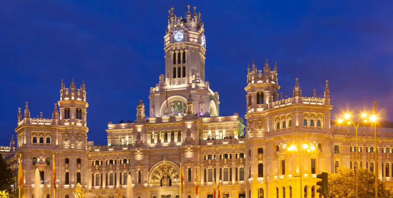 Palacio de Cibeles iluminado al anochecer, uno de los lugares más emblemáticos que ver en Madrid