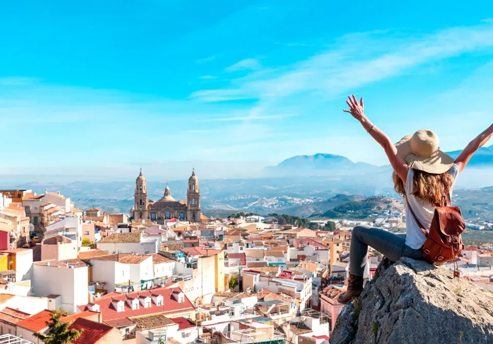 Vista panorámica de ciudad española con viajera disfrutando del paisaje tras cumplir los requisitos para viajar a España siendo mexicano.
