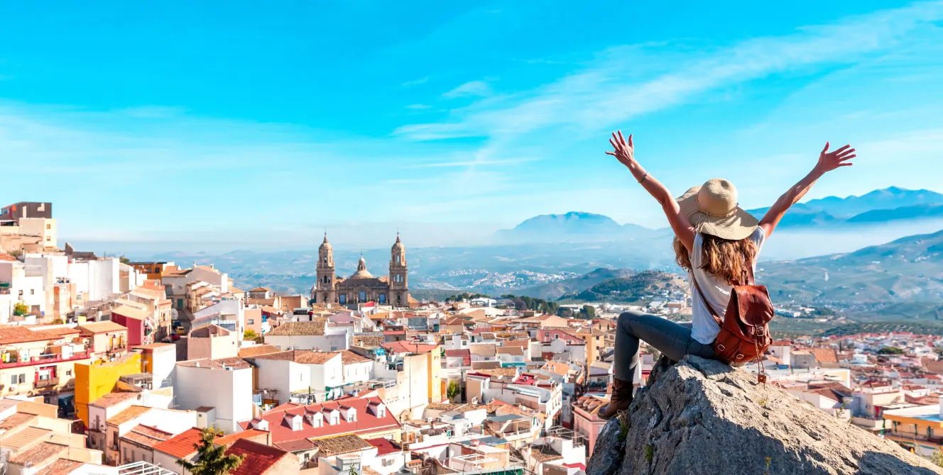 Vista panorámica de ciudad española con viajera disfrutando del paisaje tras cumplir los requisitos para viajar a España siendo mexicano.