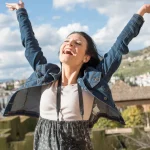 Mujer celebra con los brazos abiertos la calidad de vida en España en un mirador de Granada