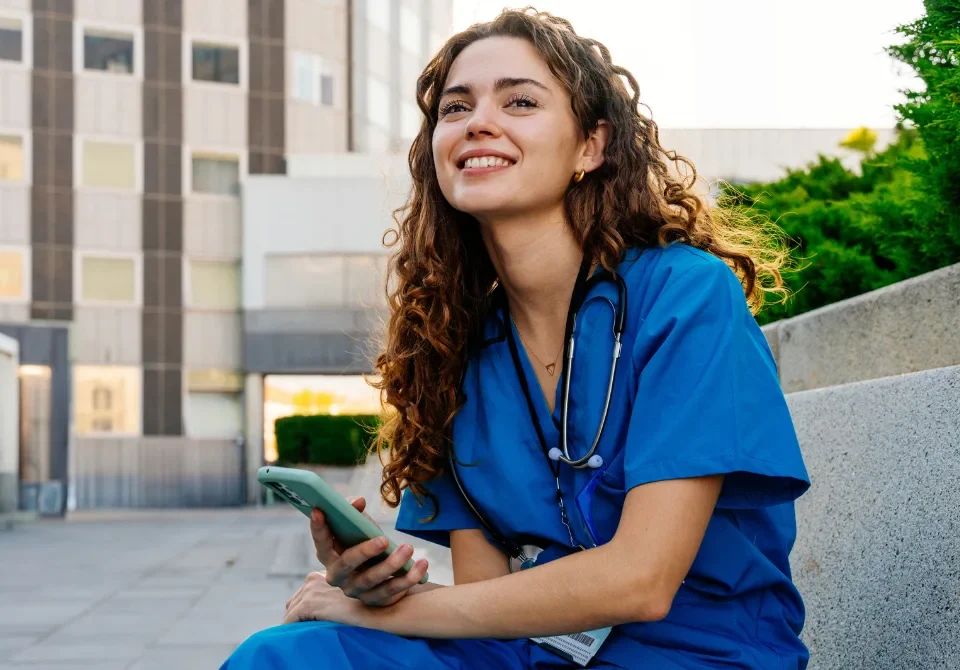 Médica residente sonriendo frente a un hospital tras entender qué es el MIR en España