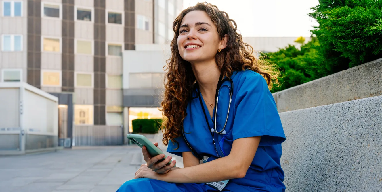 Médica residente sonriendo frente a un hospital tras entender qué es el MIR en España