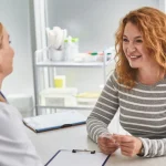 Paciente extranjera en consulta médica tras obtener su tarjeta sanitaria para extranjeros con NIE en España